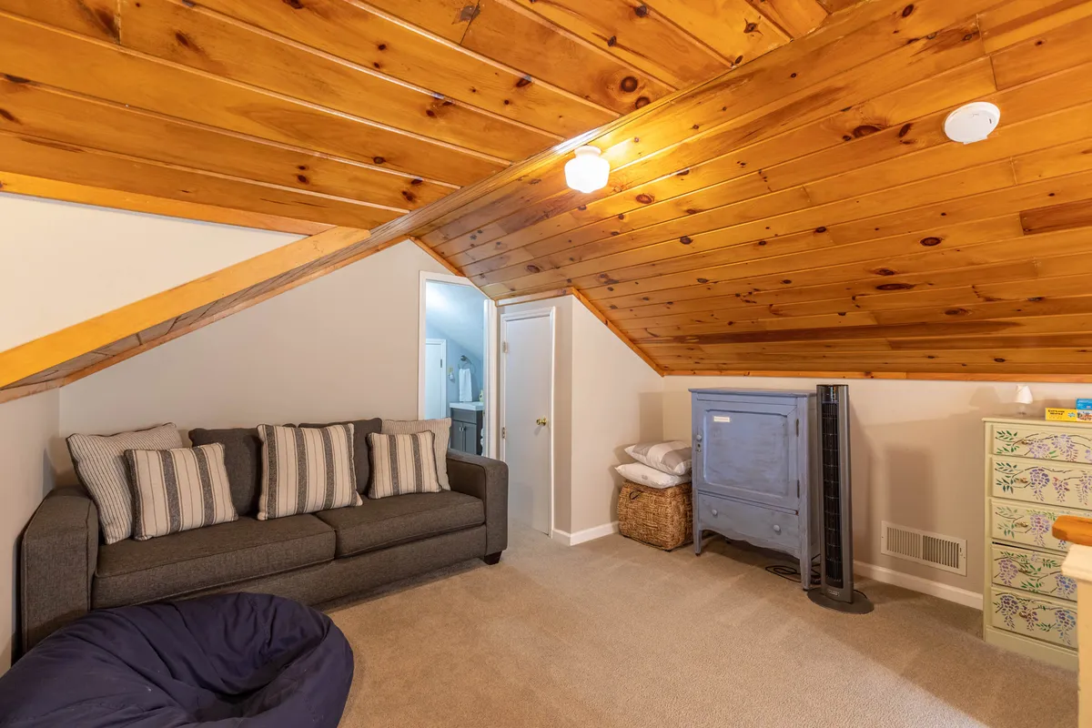A cozy living area with a striped-cushion sofa, blue chest of drawers, and a bean bag chair, creating a relaxed, informal vibe. The space encourages relaxation with its soft furnishings and abundant natural light, suggesting a comfortable spot for unwinding after adventures.